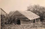 Original title:  Photograph Courtesy of Norfolk County Archives.

Details: Original cabin of Dr. John Troyer, Norfolk's first white settler.  One story cabin built of "blocks" (square-cut logs piled for walls -- evidently not shaped to interlock at corners), rough-cut planks across gable, wooden shakes on roof. Located at Troyer Flats, east of Port Rowan.  