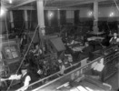 Original title:  Interior view of the Montreal Star Composing Room showing men busy at multiple work stations and manager seated at desk. 
