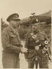 Original title:  Henry Duncan Graham Crerar standing with a man in uniform wearing a kilt and holding bagpipes. 