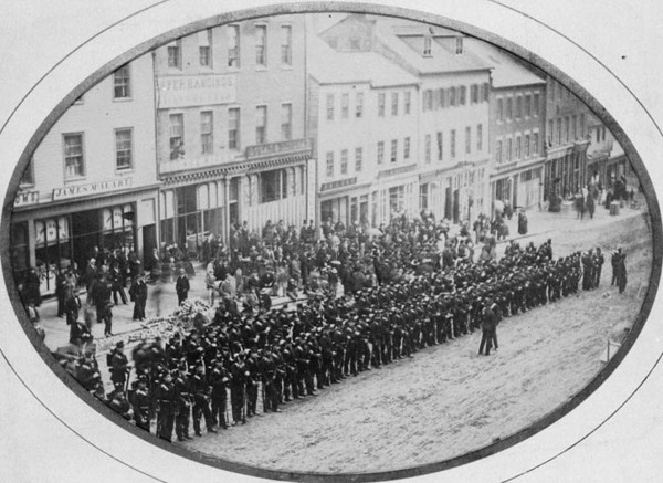 Original title:  MIKAN 3245155 King Street, Saint John, N.B. - Guard of Honour 4/60 Rifles to receive Lt. Gen. Sir H. Doyle. 1867-1873 [106 KB, 760 X 553]