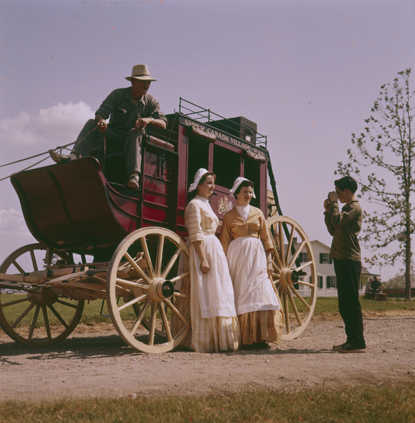 Original title:  MIKAN 4314222 Two dairy maids in costume of the late 1800&#39;s standing in front of a covered stage coach. Upper Canada Village.   septembre 1961 [206 KB, 1000 X 1018]