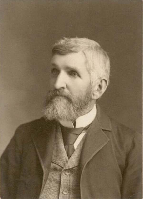 Titre original :  Black and white photograph of man in a suit with full beard
