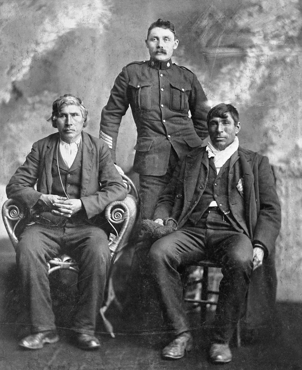 Titre original :  L-R: unknown; Sergeant K. J. Anderson; Moostoos [Mostos], Cree chief. Date: c. 1904. Image courtesy of Glenbow Museum, Calgary, Alberta.