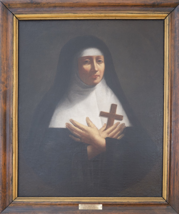 Titre original :  Tableau peint. Portrait de mère St-Joseph. Religieuse : robe et voile noir. Guimpe et bandeau blanc. Mains croisées sur son cœur. Tient une croix de bois.