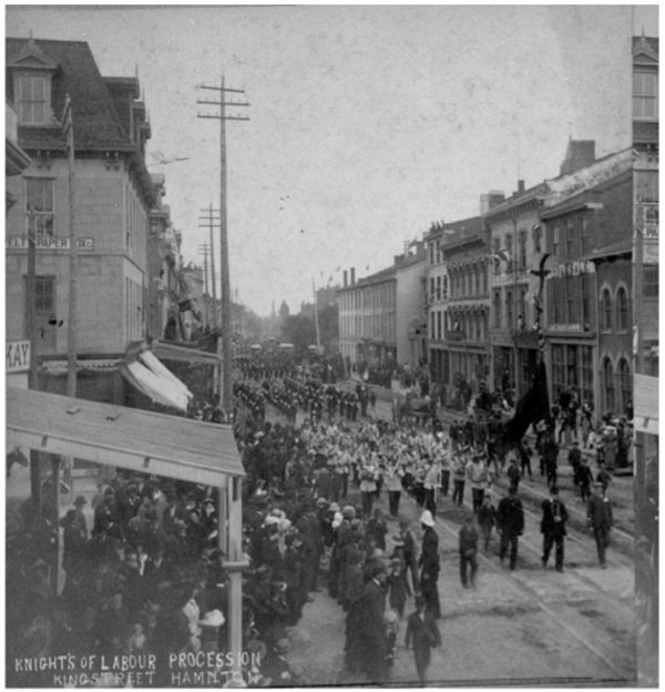 Titre original :  Few photographs of the Knights of Labor remain, but this surviving photo illustrates the union in action, marching down King Street in Hamilton, where McVicar lived, in 1885. Image courtesy of the Edward McCann Collection, Library and Archives Canada. 
https://definingmomentscanada.ca/all-for-9/historical-articles/katie-mcvicar-knights-of-labor-organization-of-women-workers/